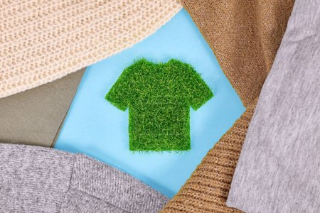 Foto de Concepto para ropa ecológica producida con camisa hecha de hierba rodeada de suéteres - Imagen libre de derechos