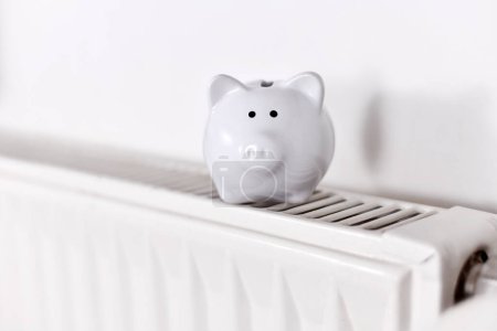 Photo for Concept for saving money for gas for heating with piggy bank on radiator with copy space - Royalty Free Image