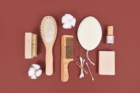Productos ecológicos de belleza e higiene de madera como peine y jabón sobre fondo marrón