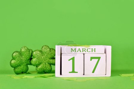 St. Patricks Day Feiertagskalender Datum 17. März mit Shamrocks auf grünem Hintergrund mit Kopierraum