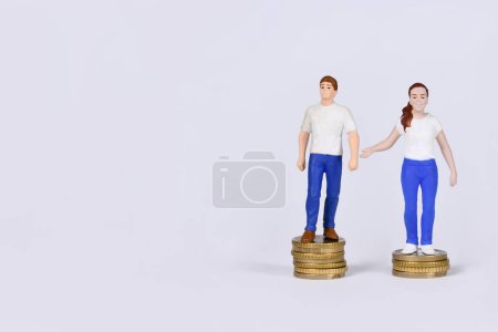 Téléchargez les photos : Concept de l'écart de rémunération entre les sexes avec l'homme et la femme debout sur différentes quantités de pièces avec espace de copie - en image libre de droit