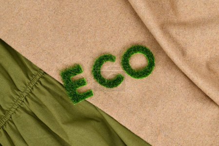 Concept for environmental friendly produced clothing with text 'ECO' made out of grass on textiles