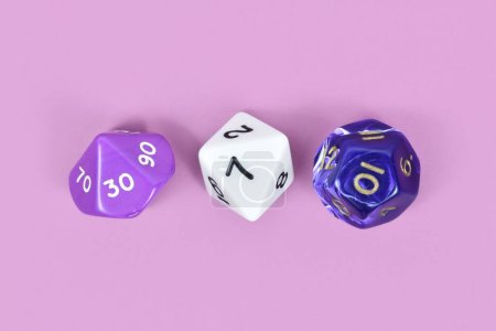 Téléchargez les photos : Trois différents jeux de rôle dés RPG sur fond violet - en image libre de droit