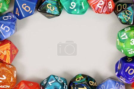 Photo for Colorful role playing RPG dice forming border around gray background with copy space - Royalty Free Image