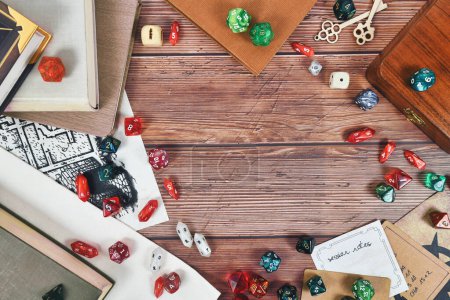Tabletop role playing flat lay background with colorful RPG dices, rule books and notes on wooden background with copy space in middl