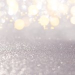 Blurred silver with yellow defocused background with sparkle. Christmas, New Year, March 8, birthday, International Women's Day. Copy space