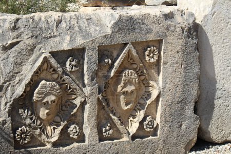 Historisches Basrelief aus Stein mit geschnitzten Gesichtern in der antiken Stadt Myra an einem sonnigen Tag. Tote Zivilisation. Ruinen von Felsengräbern in der Region Lykien, Demre, Antalya, Turkiye