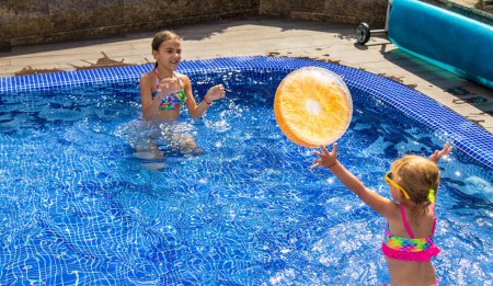 Téléchargez les photos : Un enfant joue avec une balle dans la piscine. Concentration sélective. Enfant.. - en image libre de droit