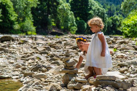 Photo for Children throw stones into the river. Selective focus. Kid. - Royalty Free Image