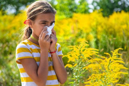 Ein Kind reagiert allergisch auf Ragweed, das im Park blüht. Selektiver Fokus. Natur.