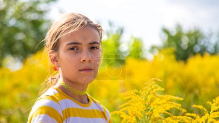 Téléchargez les photos : Un enfant est allergique à la floraison de l'herbe à poux dans le parc. Concentration sélective. Nature. - en image libre de droit