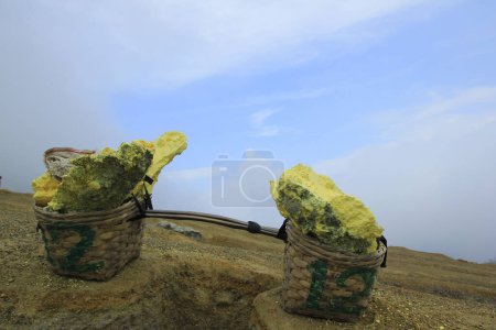 Sulfur stone is placed in a basket to be transported by miners in Ijen Crater, East Java, Indonesia
