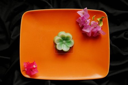 A sweet snack made from hunkwe flour which is formed using a flower pudding mold.
