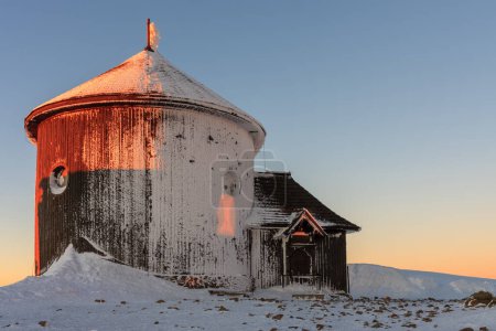 Winter, sunrise time, wooden Roman catholic chapel  in snezka, mountain on the border between Czech Republic and Poland.