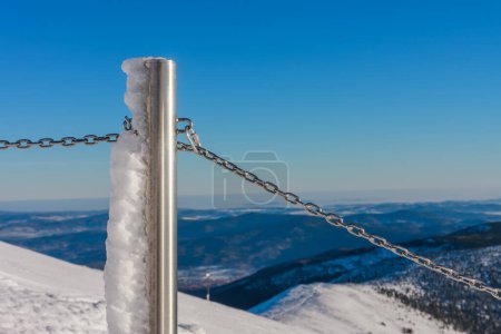 Steel railing tube with a chain, top of path to snezka from pink mountain, krkonose mountain, winter morning. 