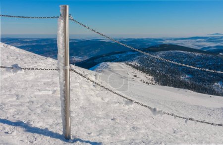 Steel railing tube with a chain, top of path to snezka from pink mountain, krkonose mountain, winter morning.