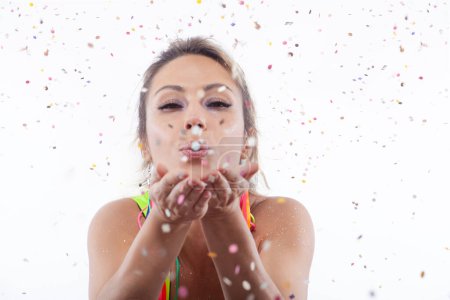 Photo for Woman isolated on a white background blowing colorful confetti horizontally - Royalty Free Image