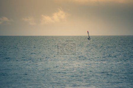 Téléchargez les photos : One windsurfer in the sea. Turquoise sea, clear blue sky without clouds - en image libre de droit
