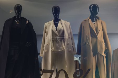 Weibliche Schaufensterpuppen in eleganten Mänteln in einem Schaufenster. Mode