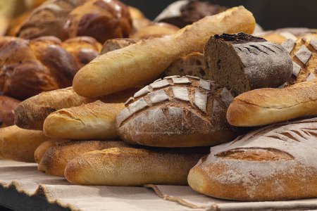Different kinds of fresh bread on the bakery counter. Food