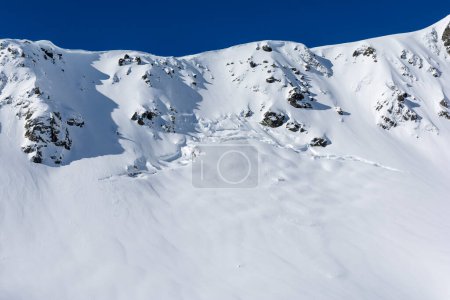 Téléchargez les photos : Fissure sur une pente abrupte de neige dans les montagnes, qui est la première étape de la formation d'une avalanche dite printanière (au sol). - en image libre de droit