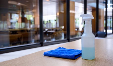 Photo for Cleaner disinfectant spray bottle with blue microfiber cloth on table. Cleaning products for disinfection. Sanitizer to prevent Coronavirus or Covid-19. Pandemic prevention and control - Royalty Free Image