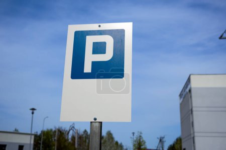 A parking sign stands in front of a building.