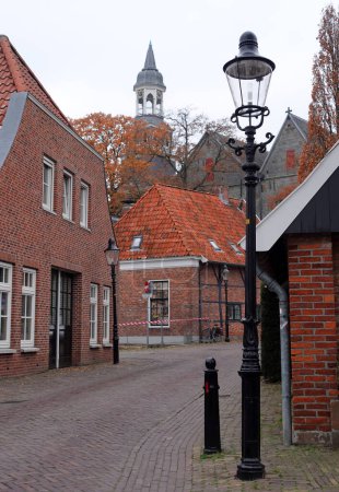 Téléchargez les photos : Rue avec vieux lampadaires dans le village d'Ootmarsum, aux Pays-Bas, un jour d'hiver en décembre - en image libre de droit