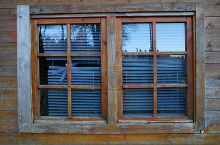Téléchargez les photos : Une fenêtre dans un abri de jardin avec stores cassés. Le bois teinté a également connu de meilleurs jours - en image libre de droit