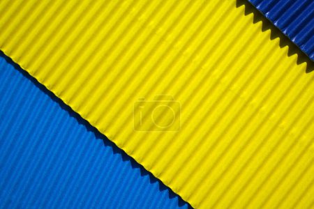 Photo for Diagonally ribbed cardboard with the colors blue, yellow, indigo. Meant as background - Royalty Free Image