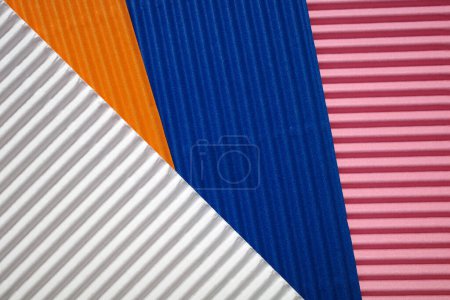 Photo for Horizontally and diagonally ribbed cardboard with the colors pink, white, orange and blue. Meant as background - Royalty Free Image