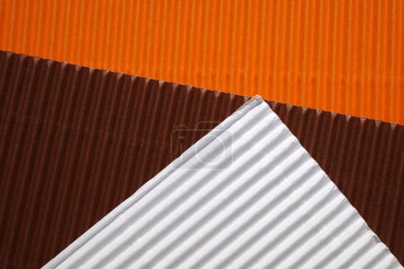Photo for Diagonally ribbed cardboard with the colors brown, white, orange. A color combination loved in the seventies. Meant as background - Royalty Free Image