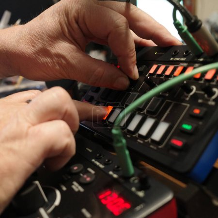 Manos de un hombre operando un mini sintetizador