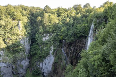 Foto de Cascadas en las escarpadas rocas de piedra del cañón del río Korana, Croacia en los lagos de Plitvice, cubiertas de un denso bosque verde - Imagen libre de derechos