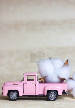 Photo for Pink vintage car pickup truck children's toy car and cotton flower, selective focus - Royalty Free Image