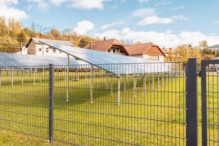 Foto de Paneles solares en fila detrás de la cerca en la granja agrícola privada - Imagen libre de derechos