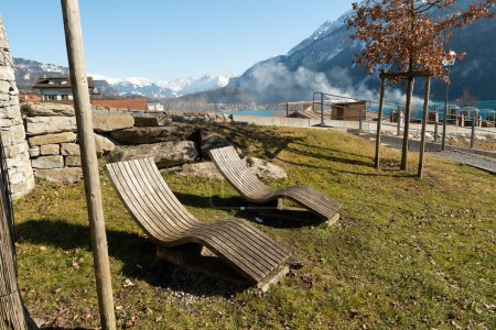 Téléchargez les photos : Brienz, Switzerland, February 10, 2023 Lounge chairs on a little hill with a fantastic view over the lake of Brienz surrounded with an alpine scenery - en image libre de droit