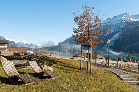 Téléchargez les photos : Brienz, Suisse, 10 février 2023 Chaises longues sur une petite colline avec une vue fantastique sur le lac de Brienz entouré d'un paysage alpin - en image libre de droit