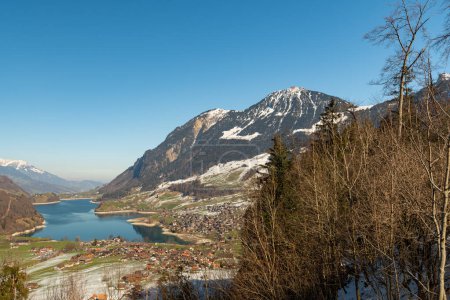 Photo for Lungern, Canton Obwalden, Switzerland, February 10, 2023 Incredible beautiful view over the lake of Lungerersee in an alpine scenery - Royalty Free Image