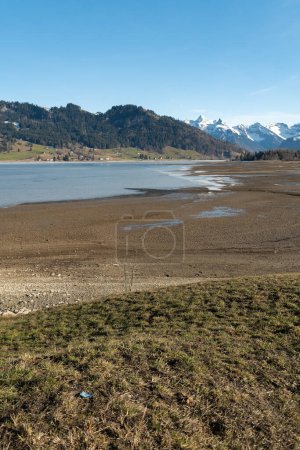 Photo for Einsiedeln area, Canton Schwyz, Switzerland, February 20, 2023 Beautiful view over the lake Sihlsee on a sunny day - Royalty Free Image