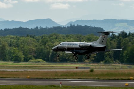 Téléchargez les photos : Zurich (Suisse), le 13 juillet 2023 L'avion HB-VAJ Embraer Phenom 300E atterrit sur la piste 14 - en image libre de droit