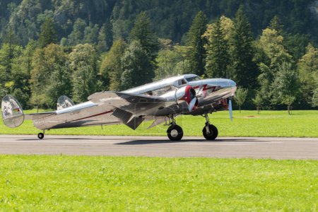 Foto de Mollis, Suiza, 18 de agosto de 2023 NC-18125 Lockheed Model 12 Electra Junior historic aircraft is taxiing on the runway - Imagen libre de derechos