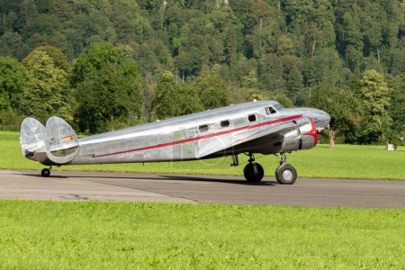 Foto de Mollis, Suiza, 18 de agosto de 2023 NC-81125 Lockheed Model 12 Electra Junior aircraft is taxiing on the runway - Imagen libre de derechos