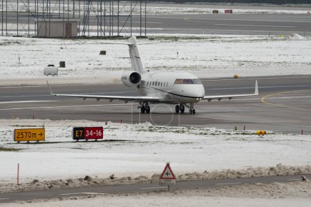 Photo for Zurich, Switzerland, December 6, 2023 D-AAAX Bombardier Challenger 604 aircraft is taxiing to its takeoff position in the winter time - Royalty Free Image