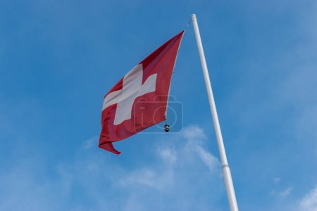 Téléchargez les photos : Salez, Suisse, 10 mars 2023 Le drapeau national suisse flotte dans le ciel bleu - en image libre de droit