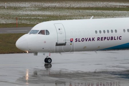 Photo for Zurich, Switzerland, January 17, 2024 OM-BYC Slovak Government Fokker 100 aircraft is taxiing through the rain during the world economic forum in Davos - Royalty Free Image