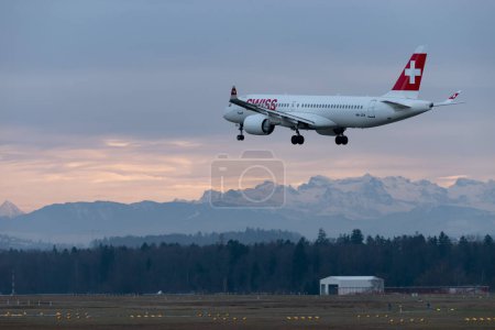 Foto de Zurich, Suiza, 14 de enero de 2024 HB-JCK Swiss Bombardier CS-300 o Airbus A220-300 aterrizan en la pista 14 por la noche - Imagen libre de derechos