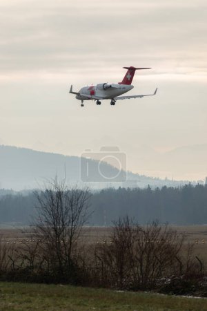 Foto de Zurich, Suiza, 16 de enero de 2024 HB-JWA REGA ambulancia aérea suiza Bombardier Challenger 650 aeronaves en su aproximación final a la pista 14 - Imagen libre de derechos