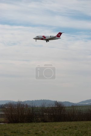 Foto de Zurich, Suiza, 16 de enero de 2024 HB-JWA REGA ambulancia aérea suiza Bombardier Challenger 650 aeronaves en su aproximación final a la pista 14 - Imagen libre de derechos