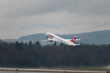 Foto de Zurich, Suiza, 17 de enero de 2024 HB-JCT Swiss Airbus A220-300 o Bombardier CS-300 despegan de la pista 28 en un día lluvioso - Imagen libre de derechos